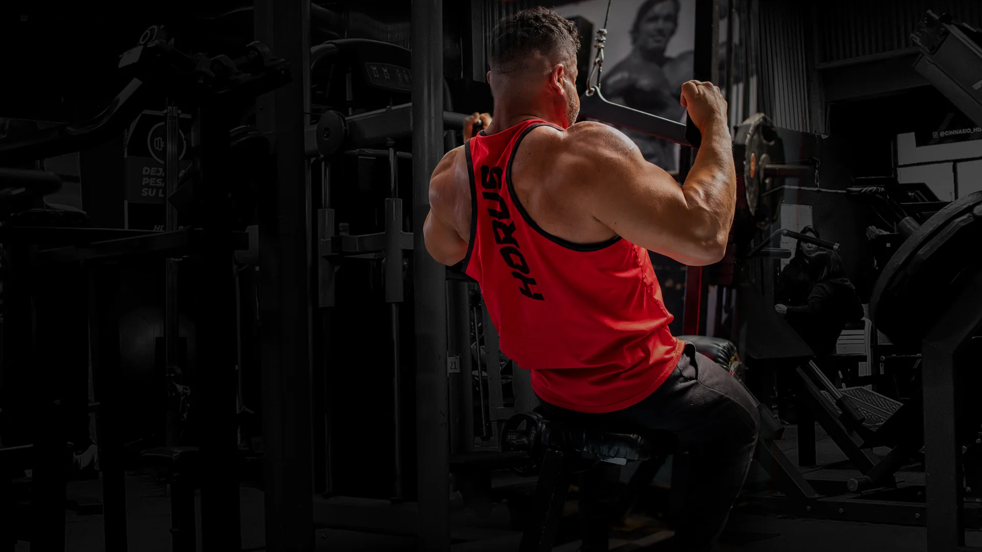 Alumno con polera roja Horus entrenando espalda en polea